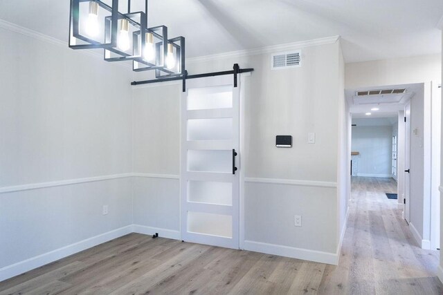 2243 W Alabama St Unit 10, Houston, TX 77098 - entrance foyer with a barn door, wood finished floors, crown molding, and baseboards
