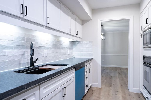 2243 W Alabama St Unit 10, Houston, TX 77098 - kitchen featuring a sink, appliances with stainless steel finishes, dark countertops, white cabinets, and light wood finished floors