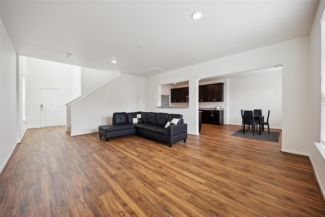 10127 Clearwick St, Houston, TX 77034 - living area featuring wood finished floors, stairway, baseboards, and recessed lighting
