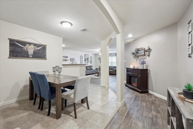 6011 Treasure Cove Rd, Cove, TX 77523 - dining area featuring arched walkways, baseboards, recessed lighting, light wood-style flooring, and a textured ceiling