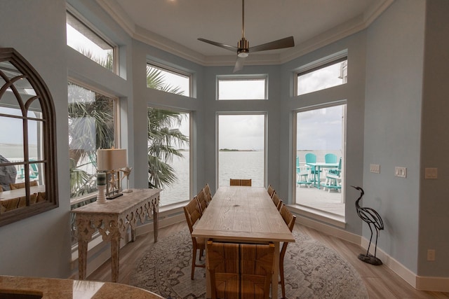 1827 Port O Call St, Tiki Island, TX 77554 - dining area with ornamental molding, a water view, ceiling fan, light wood-style flooring, and baseboards