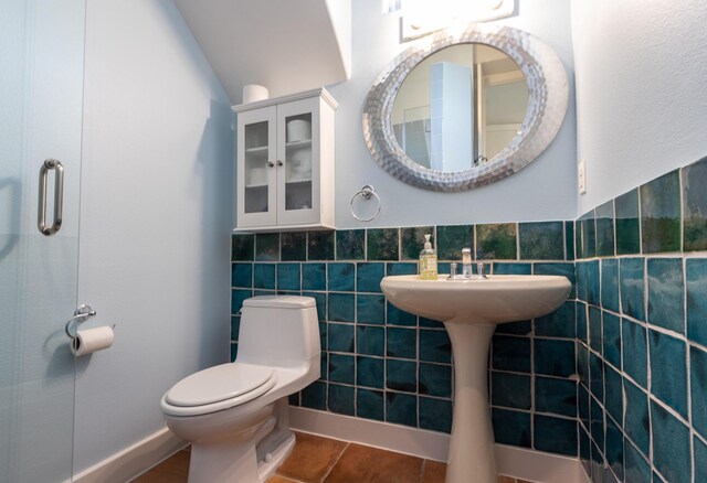 1827 Port O Call St, Tiki Island, TX 77554 - bathroom with toilet, tile patterned floors, tile walls, and a wainscoted wall