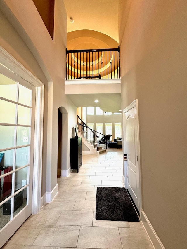 7739 Augusta Creek Ct, Spring, TX 77389 - foyer entrance with baseboards, stairway, arched walkways, and a high ceiling
