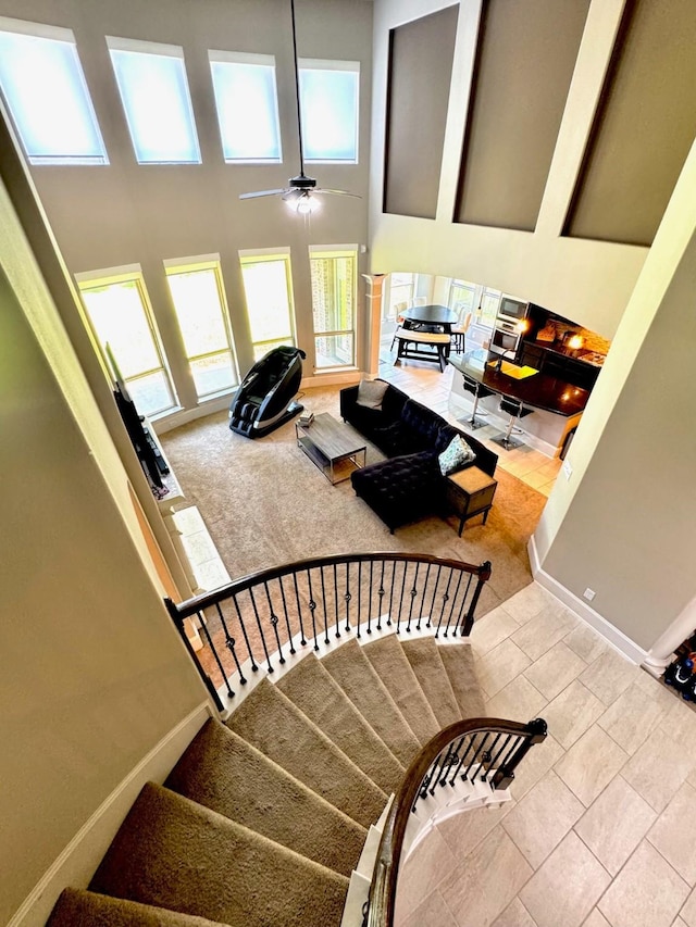 7739 Augusta Creek Ct, Spring, TX 77389 - staircase with a ceiling fan, a towering ceiling, and tile patterned flooring