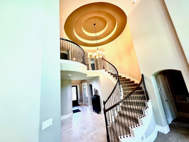 7739 Augusta Creek Ct, Spring, TX 77389 - stairs featuring arched walkways, baseboards, a chandelier, and a towering ceiling
