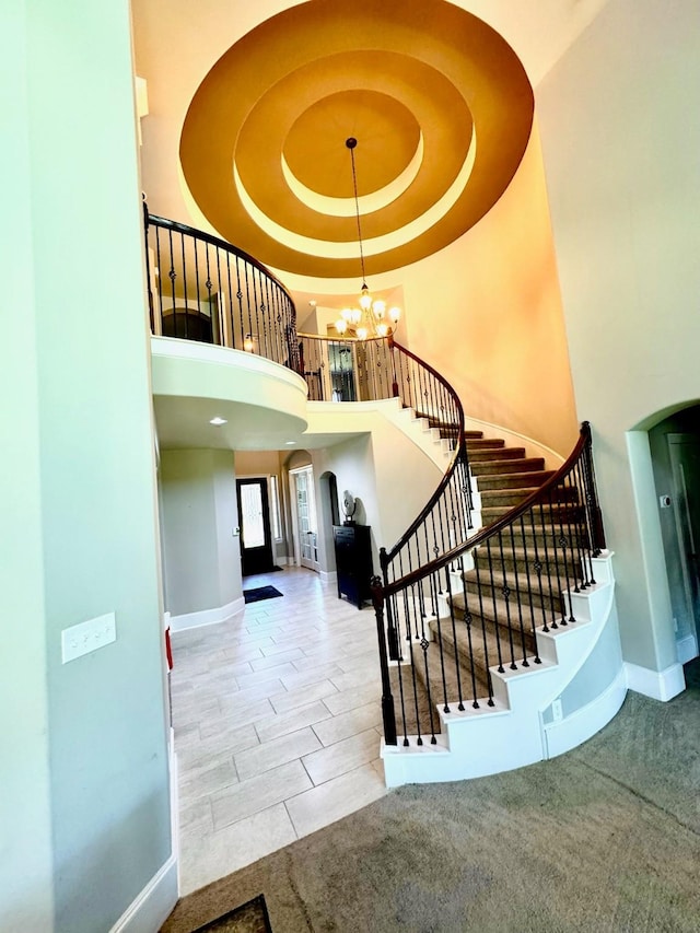 7739 Augusta Creek Ct, Spring, TX 77389 - stairway featuring arched walkways, baseboards, a chandelier, and a towering ceiling