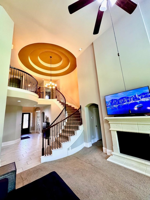 7739 Augusta Creek Ct, Spring, TX 77389 - carpeted living area featuring a towering ceiling, baseboards, stairs, arched walkways, and a chandelier