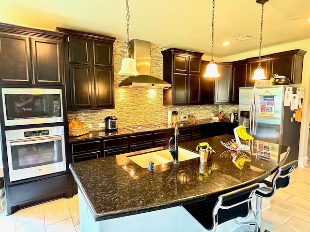 7739 Augusta Creek Ct, Spring, TX 77389 - kitchen featuring appliances with stainless steel finishes, wall chimney range hood, tasteful backsplash, a breakfast bar area, and recessed lighting