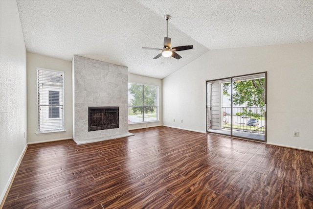 6701 Sands Point Dr Unit 129, Houston, TX 77074 - unfurnished living room with ceiling fan, a tiled fireplace, dark wood-style flooring, lofted ceiling, and a textured ceiling