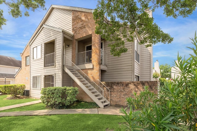 6701 Sands Point Dr Unit 129, Houston, TX 77074 - view of front of property featuring stairs, brick siding, a front lawn, and central AC