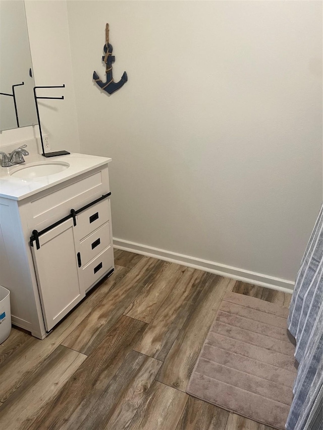 465 Creek Dr, Onalaska, TX 77360 - bathroom with vanity, wood finished floors, and baseboards