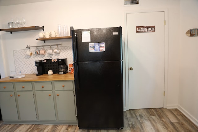 465 Creek Dr, Onalaska, TX 77360 - kitchen featuring freestanding refrigerator, wood finished floors, open shelves, decorative backsplash, and baseboards
