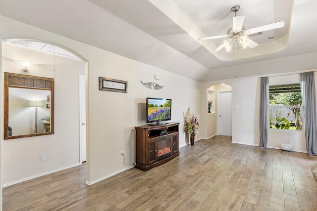 414 Laurel Sage Dr, Houston, TX 77339 - living area with arched walkways, light wood-style floors, a ceiling fan, a tray ceiling, and baseboards