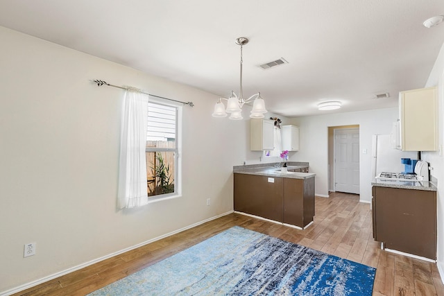 414 Laurel Sage Dr, Houston, TX 77339 - kitchen featuring light wood finished floors, white cabinetry, baseboards, light countertops, and a peninsula