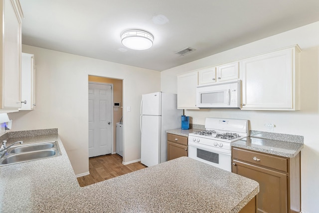 414 Laurel Sage Dr, Houston, TX 77339 - kitchen featuring white appliances, a sink, wood finished floors, light countertops, and white cabinetry