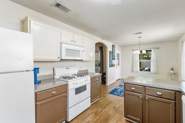414 Laurel Sage Dr, Houston, TX 77339 - kitchen featuring white appliances, arched walkways, light wood-type flooring, and light countertops