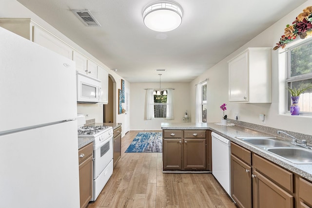 414 Laurel Sage Dr, Houston, TX 77339 - kitchen with white appliances, a sink, a peninsula, light wood-style floors, and plenty of natural light