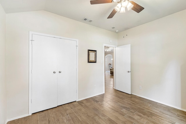414 Laurel Sage Dr, Houston, TX 77339 - unfurnished bedroom with light wood finished floors, arched walkways, vaulted ceiling, a ceiling fan, and baseboards