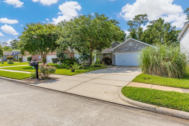 414 Laurel Sage Dr, Houston, TX 77339 - obstructed view of property featuring a garage, a front lawn, concrete driveway, and stone siding