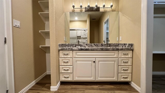 712 Lettie St, Richmond, TX 77469 - bathroom featuring vanity, baseboards, and wood finished floors