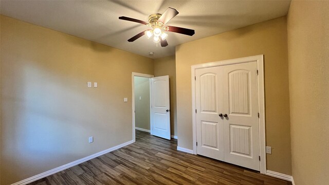 712 Lettie St, Richmond, TX 77469 - unfurnished bedroom featuring dark wood-style floors, baseboards, and a closet
