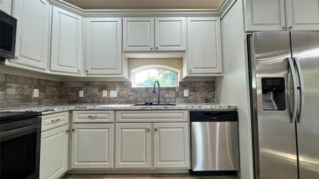 712 Lettie St, Richmond, TX 77469 - kitchen with appliances with stainless steel finishes, a sink, tasteful backsplash, and white cabinetry