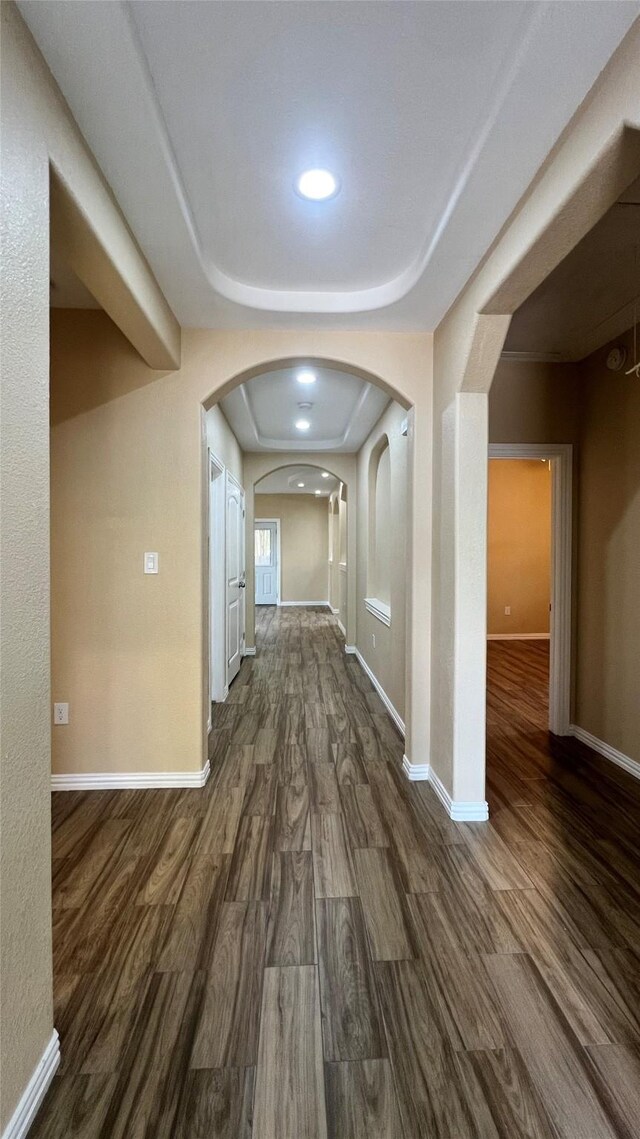 712 Lettie St, Richmond, TX 77469 - corridor featuring dark wood-style floors, baseboards, arched walkways, and recessed lighting