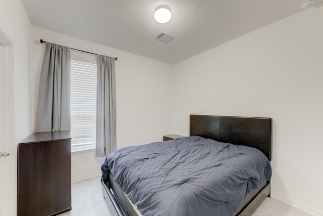 5022 Jonina Ln, Houston, TX 77048 - bedroom with multiple windows, baseboards, light tile patterned floors, and a textured ceiling