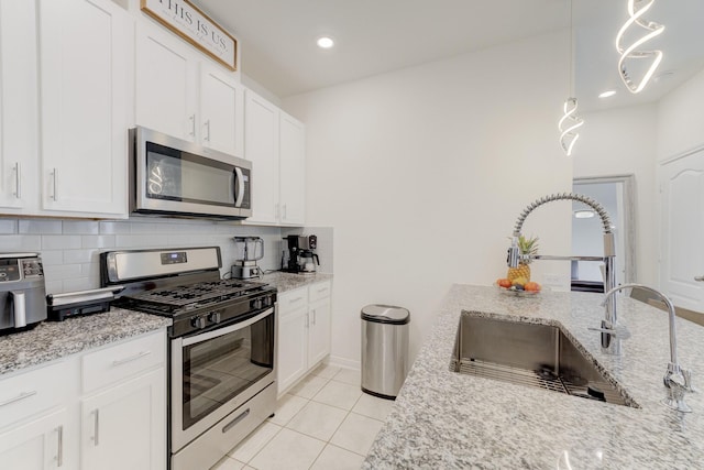5022 Jonina Ln, Houston, TX 77048 - kitchen with appliances with stainless steel finishes, decorative backsplash, white cabinets, light stone countertops, and light tile patterned flooring