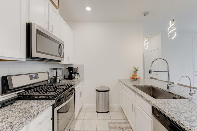 5022 Jonina Ln, Houston, TX 77048 - kitchen with stainless steel appliances, a sink, decorative backsplash, light stone counters, and white cabinets