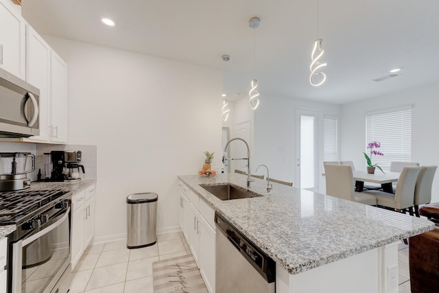 5022 Jonina Ln, Houston, TX 77048 - kitchen featuring appliances with stainless steel finishes, a sink, a peninsula, light stone counters, and white cabinets