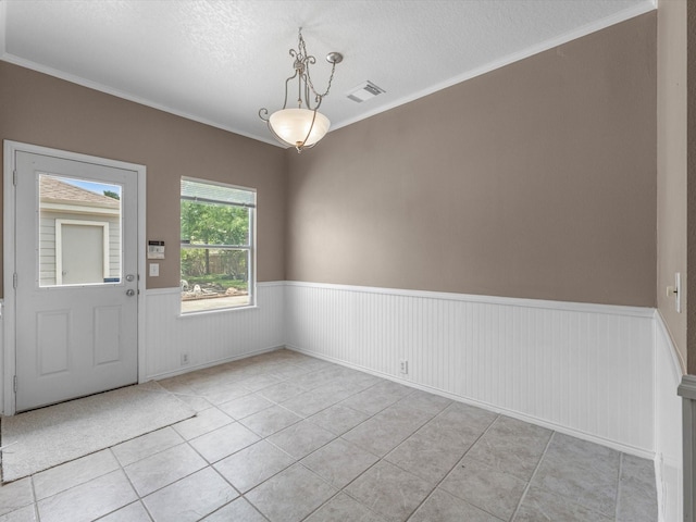 2031 Upland Hill St, Spring, TX 77373 - unfurnished dining area with a wainscoted wall, light tile patterned floors, a textured ceiling, and crown molding