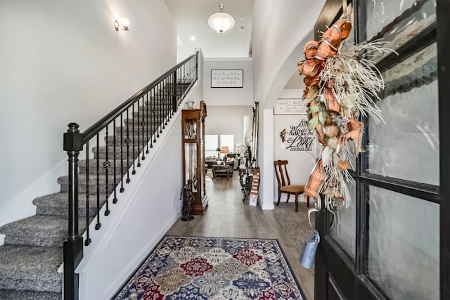 356 Selah Ct, Alvin, TX 77511 - foyer featuring wood finished floors, arched walkways, stairs, baseboards, and a high ceiling