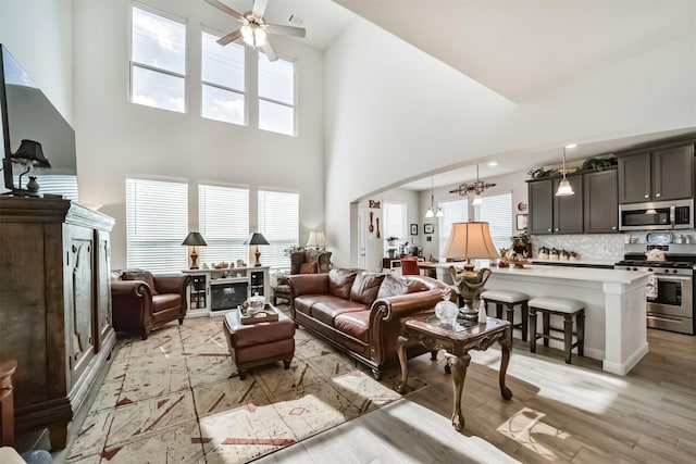 356 Selah Ct, Alvin, TX 77511 - living area featuring a towering ceiling, ceiling fan, light wood finished floors, and arched walkways