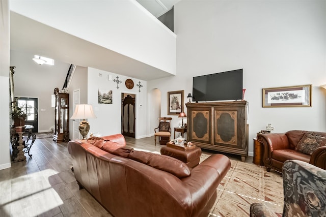 356 Selah Ct, Alvin, TX 77511 - living room featuring arched walkways, a high ceiling, baseboards, and wood finished floors