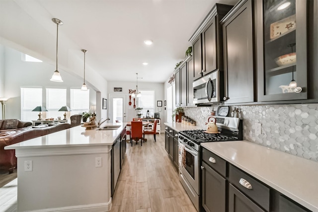 356 Selah Ct, Alvin, TX 77511 - kitchen with stainless steel appliances, a sink, light countertops, backsplash, and light wood-style flooring