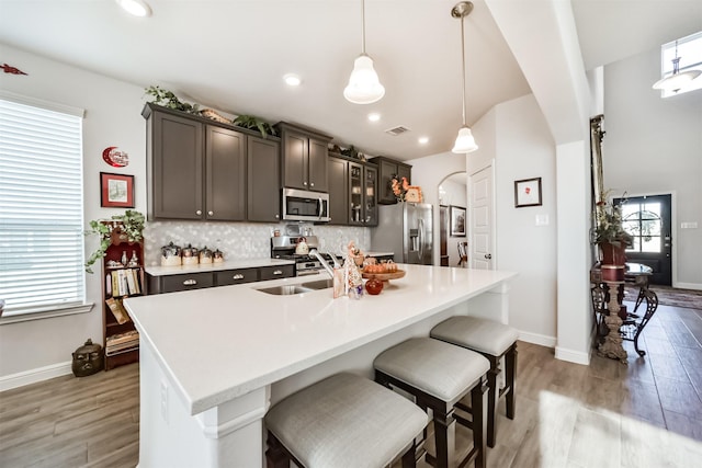 356 Selah Ct, Alvin, TX 77511 - kitchen with stainless steel appliances, light wood-type flooring, a breakfast bar, baseboards, and recessed lighting
