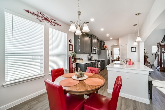 356 Selah Ct, Alvin, TX 77511 - dining room featuring arched walkways, wood finished floors, a chandelier, recessed lighting, and baseboards