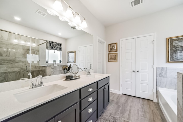 356 Selah Ct, Alvin, TX 77511 - bathroom featuring a bath, double vanity, a shower stall, and wood finished floors