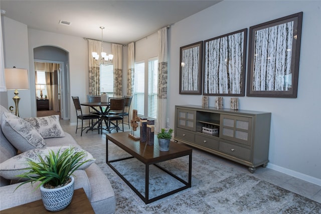 214 Emerald Thicket Ln, Humble, TX 77336 - living area featuring a chandelier, baseboards, and arched walkways