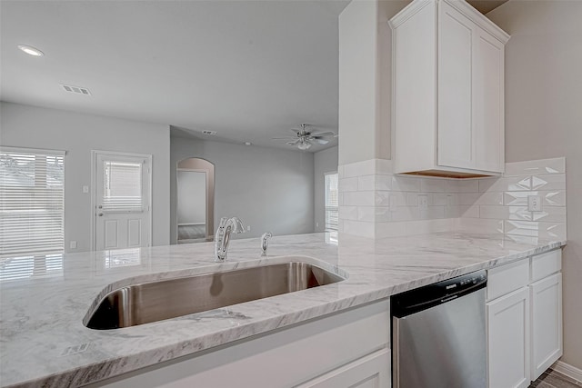 24705 Thornbluff Briar Trl, Huffman, TX 77336 - kitchen with dishwasher, a sink, light stone counters, arched walkways, and recessed lighting