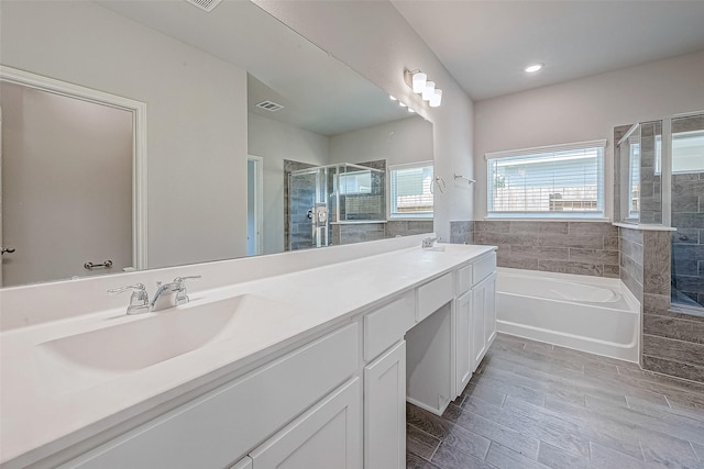 24705 Thornbluff Briar Trl, Huffman, TX 77336 - full bathroom with a stall shower, a garden tub, double vanity, wood finished floors, and recessed lighting