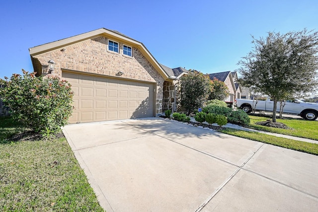 11210 Victoria Hollow Trce, Richmond, TX 77406 - view of front facade featuring stone siding, driveway, an attached garage, and brick siding