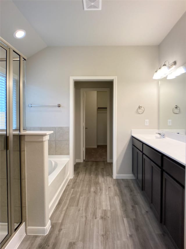 27203 Blue Pool Dr, Katy, TX 77493 - bathroom featuring vanity, a bath, wood finished floors, a stall shower, and baseboards
