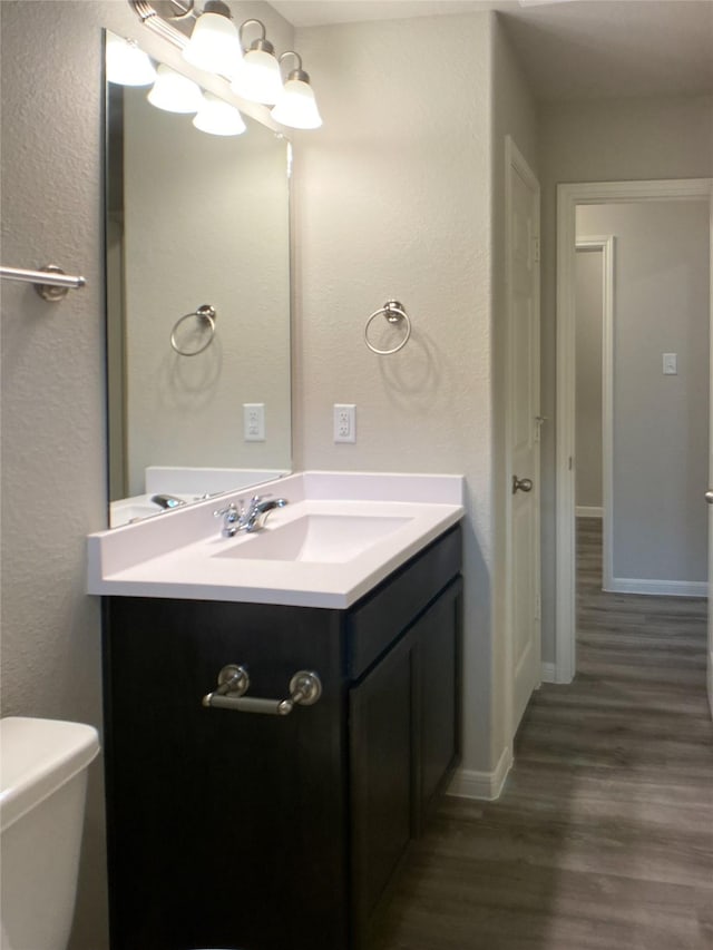 27203 Blue Pool Dr, Katy, TX 77493 - half bath featuring wood finished floors, vanity, toilet, baseboards, and a textured wall