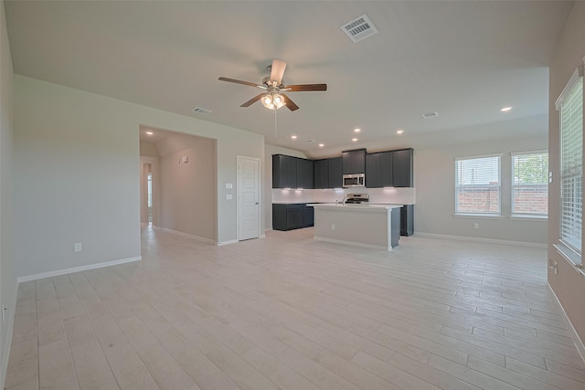 27203 Blue Pool Dr, Katy, TX 77493 - kitchen with open floor plan, appliances with stainless steel finishes, a ceiling fan, light countertops, and light wood-type flooring