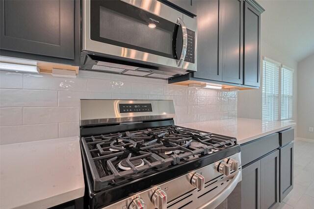 27203 Blue Pool Dr, Katy, TX 77493 - kitchen featuring appliances with stainless steel finishes, backsplash, light countertops, and baseboards