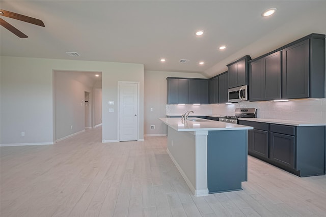 27203 Blue Pool Dr, Katy, TX 77493 - kitchen featuring stainless steel appliances, a sink, light wood-style floors, decorative backsplash, and a ceiling fan