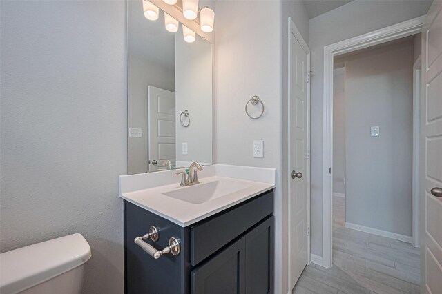 27203 Blue Pool Dr, Katy, TX 77493 - bathroom with vanity, toilet, wood finished floors, and baseboards