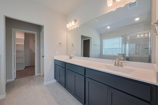27203 Blue Pool Dr, Katy, TX 77493 - bathroom with double vanity, a shower stall, a walk in closet, wood finished floors, and baseboards